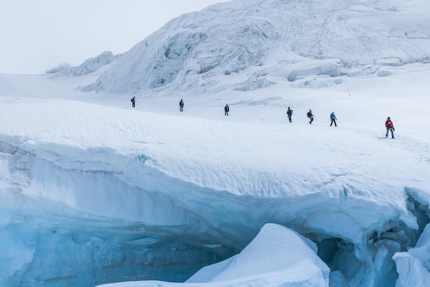 Expedition of hikers in the snowy steep mountains