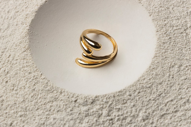 Free photo expensive golden ring with white powder background