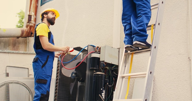 Expert and coworker servicing condenser