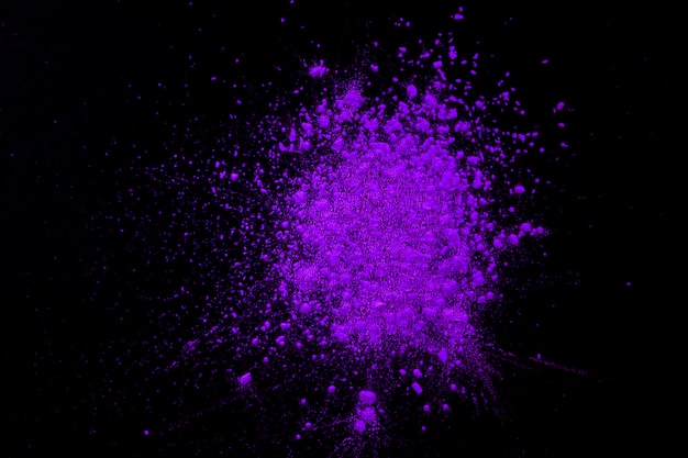 Explosion of purple dry color over black background