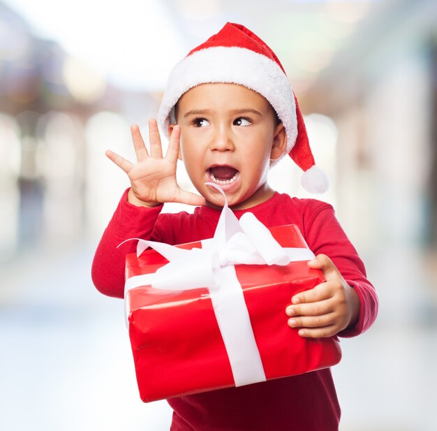 Expressive boy holding a gift with a white bow