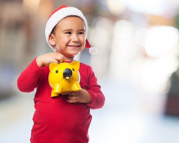 Expressive boy holding his piggybank