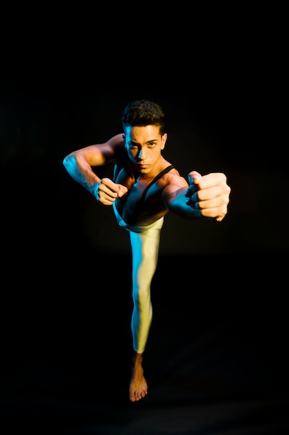 Free photo expressive male ballet performer dancing in spotlight