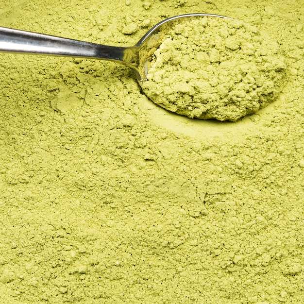 Extreme close-up organic green powder and spoon