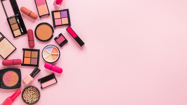 Free photo eye shadows with lipsticks on pink table