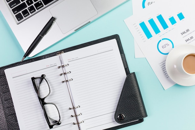 Free photo eyeglasses on diary,laptop,pen,coffee cup and budget plan on office desk