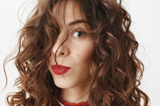 Free Photo face of stylish beautiful woman with red lipstick and curly haircut