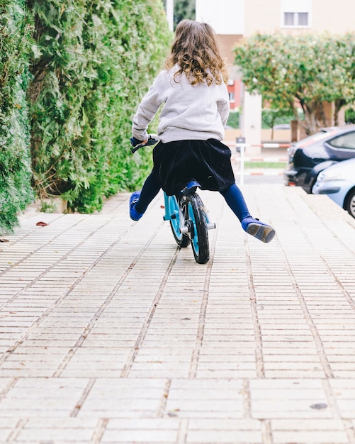 Free photo faceless girl riding bicycle