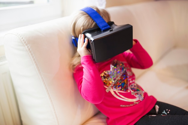 Free photo faceless girl in vr goggles on sofa