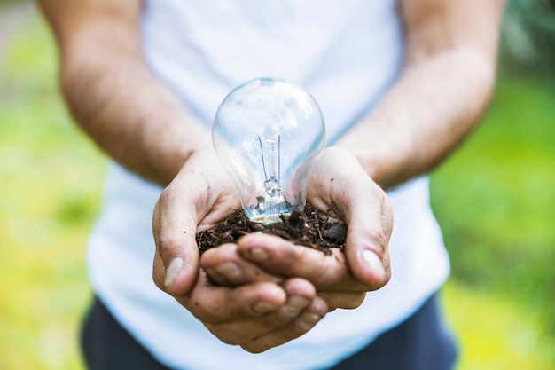 Free photo faceless man holding lamp on ground