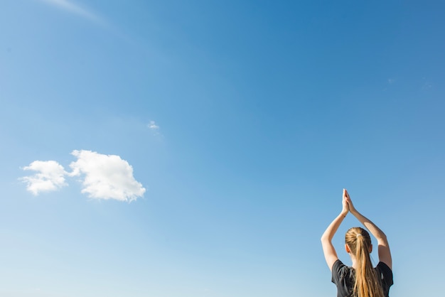 Faceless teenage doing yoga in nature