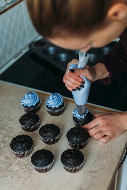 faceless woman decorating cupcakes