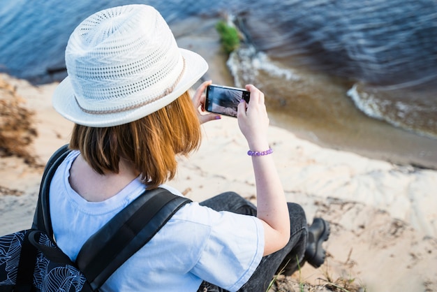 Free photo faceless woman taking picture of sea