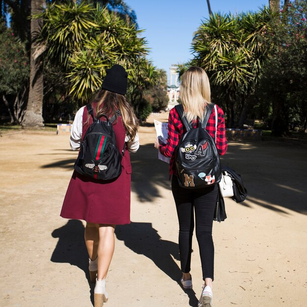 Faceless women with map walking in park