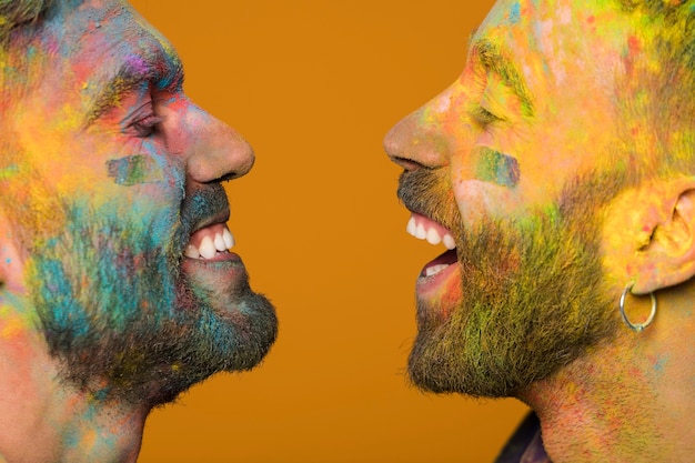 Free photo faces laughing gays soiled in paint