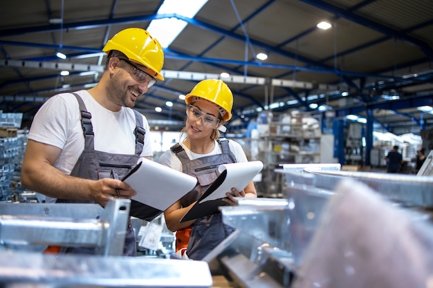 Free Photo factory workers analyzing production results in large industrial hall