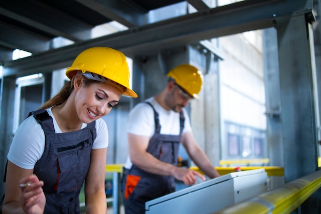 Free photo factory workers monitoring industrial machines and production remotely in control room