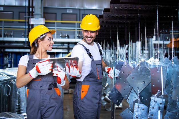 Free photo factory workers working together in industrial metal production line