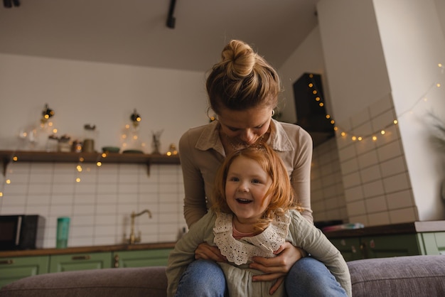 Free Photo fairskinned young mother with sweet little redhaired daughter enjoy spending time at home motherhood concept