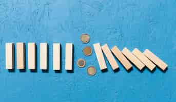 Free photo fallen wooden pieces and coins concept