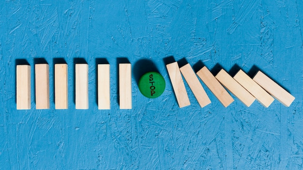 Free photo fallen wooden pieces and green stop sign concept