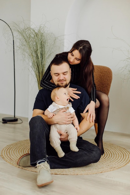 Families Portrait Of Happy Young Mother And Father with Child Posing In home Interior