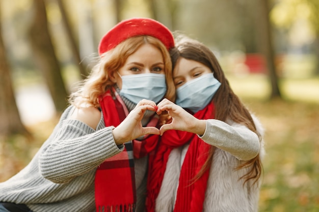 Free photo family in a autumn park. coronavirus theme. mother with daughter.