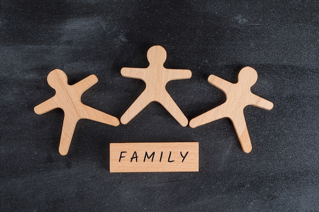 Free Photo family concept with wooden block and human figures on dark grey table flat lay.