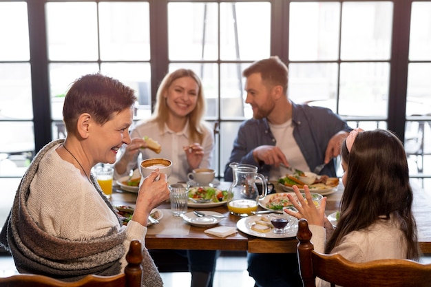 Free photo family eating together at table medium shot