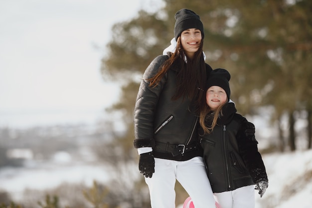 Family on family Christmas vacation. Woman and little girl in a forest. People walks.