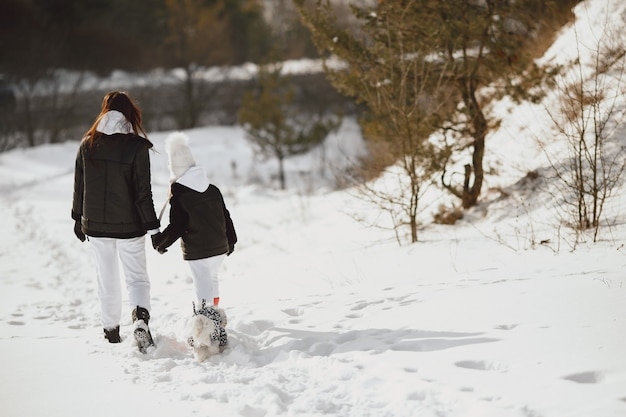 Family on family Christmas vacation. Woman and little girl in a forest. People walks.