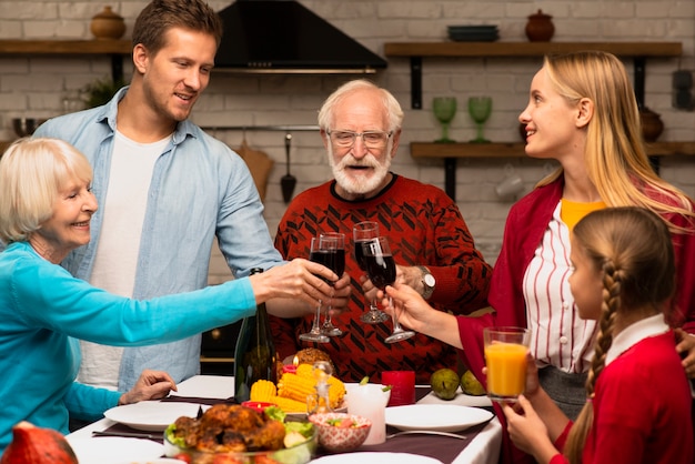 Family generations toasting glasses on thanksgiving day