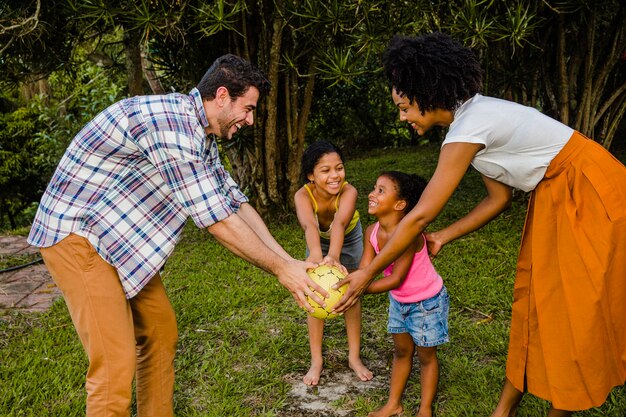 Family holding ball together