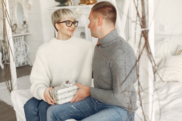 Free Photo family at home. couple near christmas decorations. woman in a gray sweater.