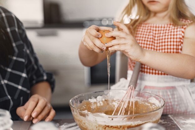 Family in a kitchen cook the dough for cookies