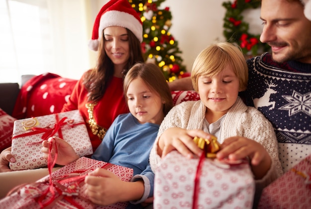 Family opening Christmas presents at home