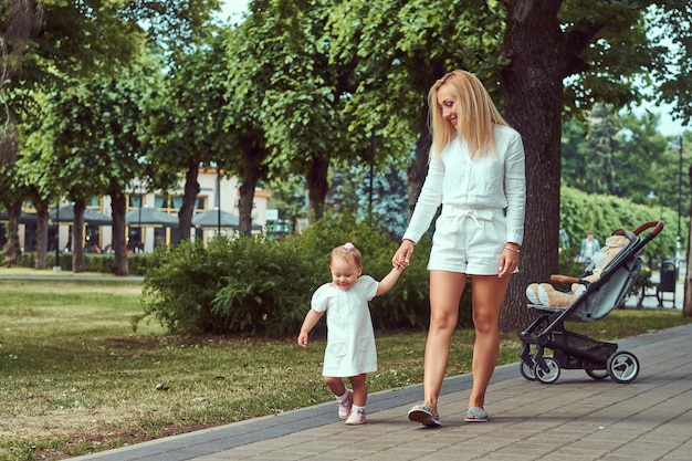 Free photo family and people concept - happy blonde mother with his little daughter in the park.