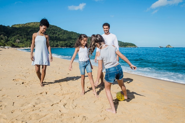 Family playing football on the beach