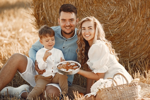 Free photo family playing with baby son in wheat field on sunset. people on a picnic. family spending time together on nature.