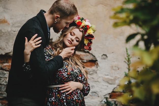 Family portrait, expacting couple. Man hugs tender pregnant woma