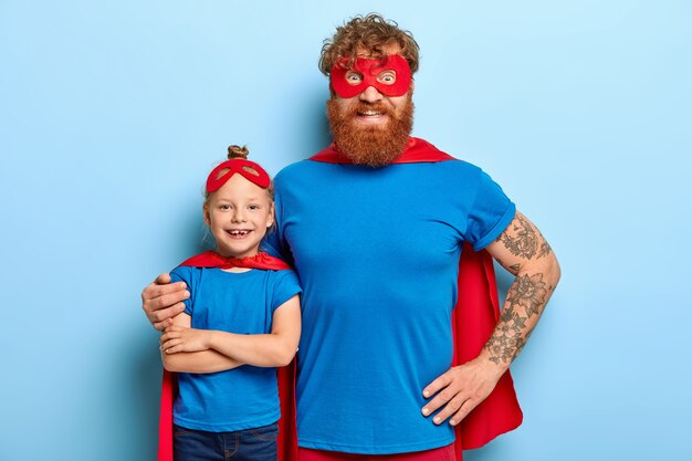 Family portrait of funny father and daughter play superhero