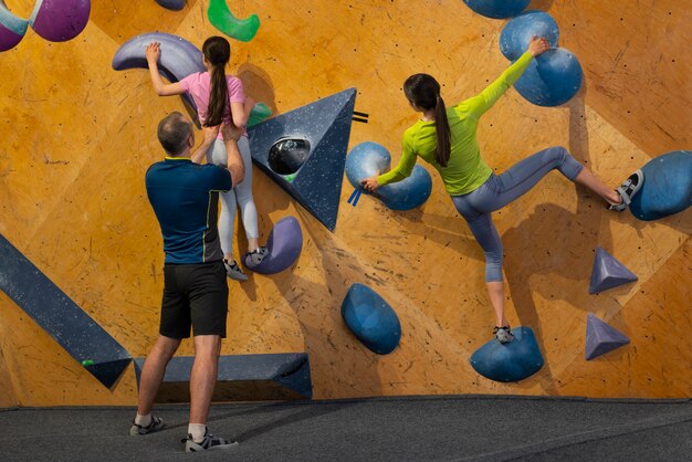 Family rock climbing together indoors at the arena