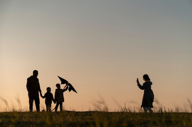 Free Photo family silhouettes having fun at sunset full shot