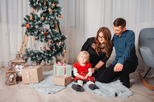 Family sitting at home near christmas tree