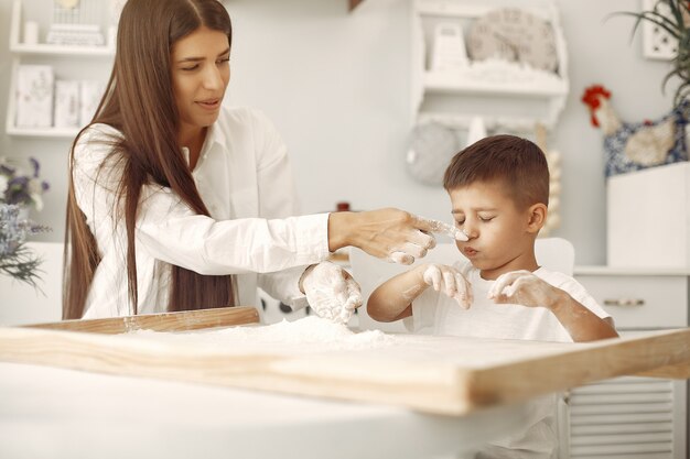 Family sitting in a kitchen and cook the dough for cookies