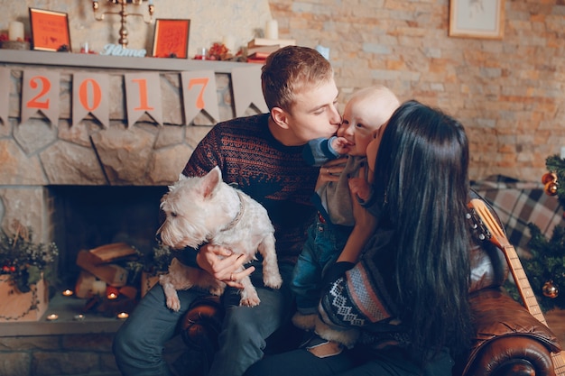 Free Photo family sitting on a sofa with dog at christmas