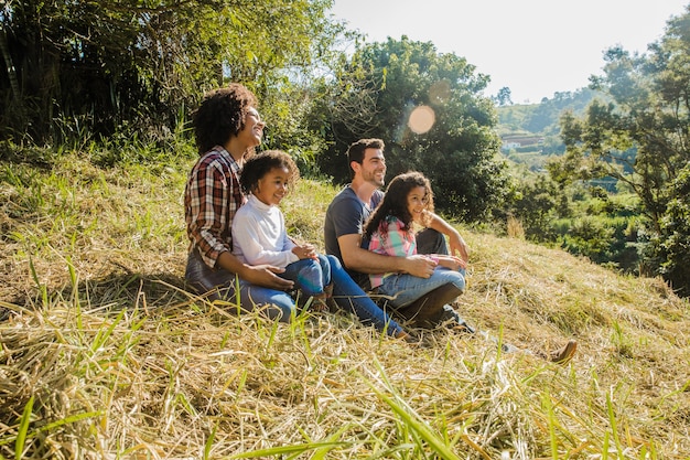 Free photo family sitting on a sunny hill