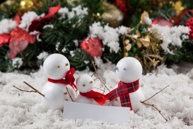 Free Photo family of snowmen with a message of merry christmas