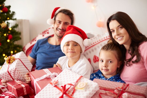 Family spending Christmas morning in bed