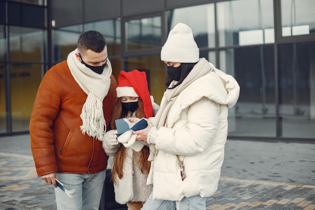 Free photo family standing outdoors wearing face mask and checking passports